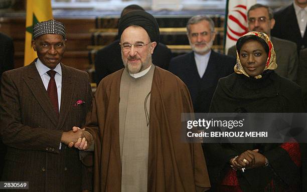 Senegalese President Abdoulaye Wade shakes hands with Iranian President Mohammad Khatami after signing the agreements between the ministers of Iran...