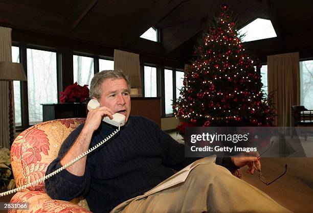 In this handout photo, President George W. Bush talks during Christmas Eve telephone calls to members of the Armed Forces at Camp David, Maryland...