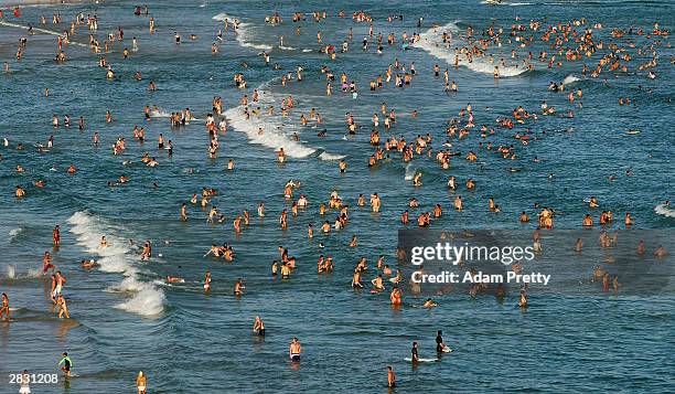 People gather at Bondi Beach to celebrate an Australian Christmas in the blazing sun at Bondi Beach on December 25, 2003 in Sydney, Australia.