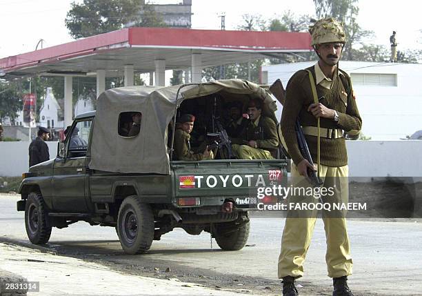 Pakistani paramilitary soldier stands guard in front of a petrol station, the site of an attempted suicide attack on Pakistani President Pervez...