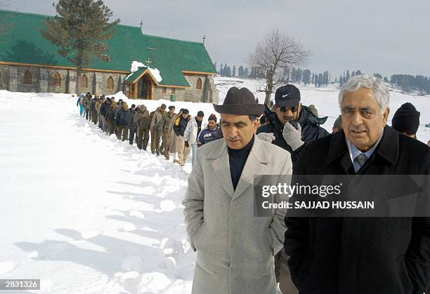 Chief Minister of Jammu and Kashmir Mufti Mohammed Sayyed walks through snow with the state's Minister of Tourism Ghulam Hassan Mir after attending a...