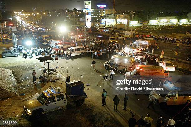 Israeli police and emergency vehicles surround the scene of a Palestinian suicide attack December 25, 2003 at a bus stop in the central Israeli town...