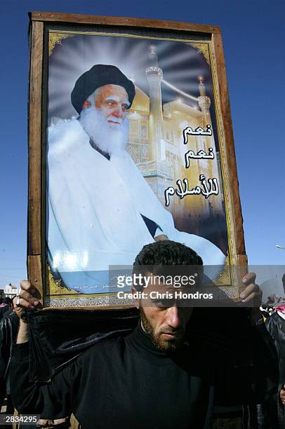 Shia Muslim holds a picture of assassinated cleric Mohammed Sadiq al Sadr December 28, 2003 in Najaf, Iraq. Sadr was killed in 1999, most likely by...