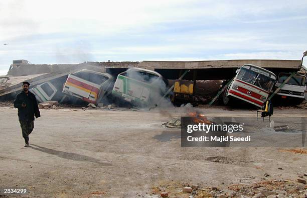 Buses sit crushed under the weight of a concrete roof December 28, 2003 in the city of Bam, Iran. An earthquake registering 6.5 on the Richter scale...