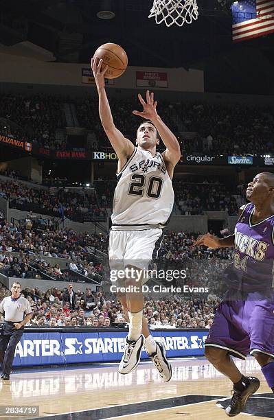 Manu Ginobili of the San Antonio Spurs lays up against Desmond Mason of the Milwaukee Bucks during the game on December 28, 2003 at the SBC Center in...