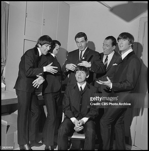 American television host Ed Sullivan poses, with members of British rock group the Beatles and Olympic speed skater Terry McDermott , backstage...