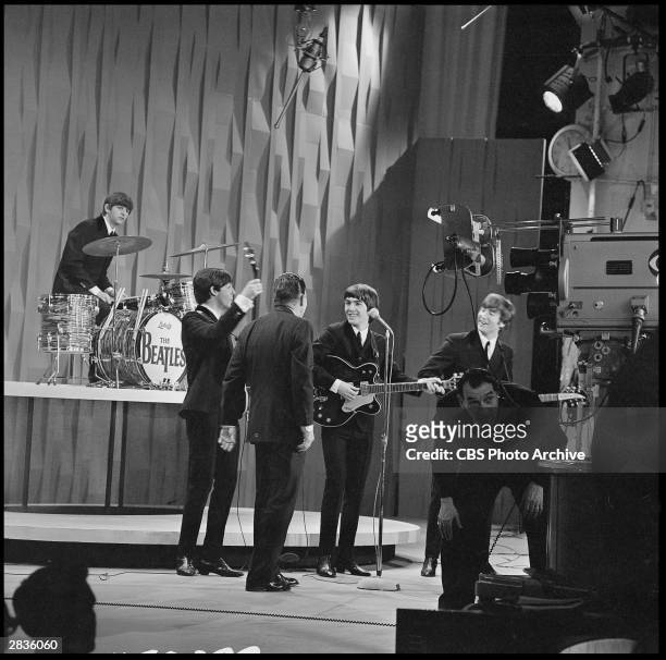 View of American television personality Ed Sullivan , with the members of British Rock group the Beatles, during an episode of 'The Ed Sullivan Show'...