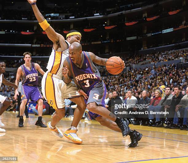 Derek Fisher of the Los Angeles Lakers defends against Stephon Marbury of the Phoenix Suns during the game on December 21, 2003 at Staples Center in...
