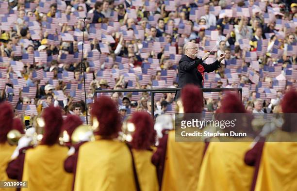Composer John Williams directs the combined marching bands of the Michigan Wolverines and the USC Trojans before the 2004 Rose Bowl on January 1,...