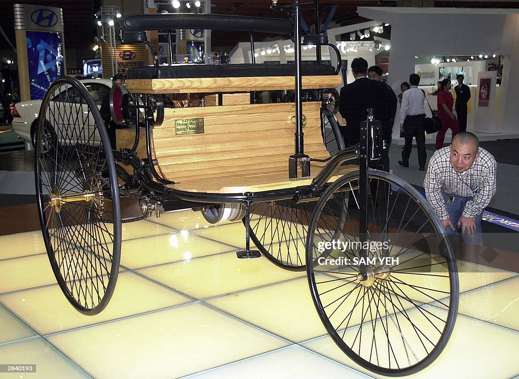 A man admires the world first car, a 1886 Benz Patent Motor Car NO ...