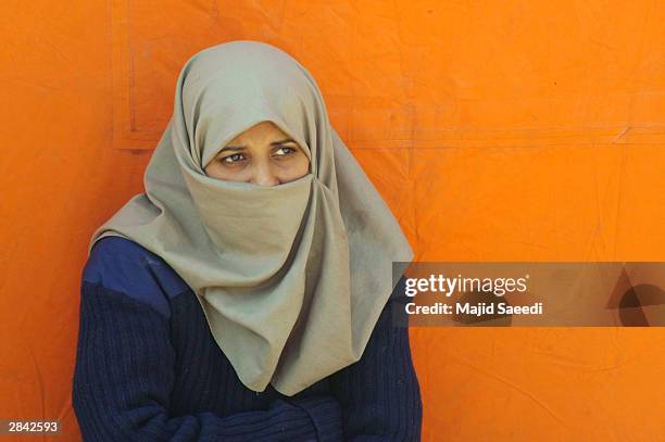 Survivor of last week's earthquake, who lost her entire family, waits to see a doctor outside a Ukrainian field hospital January 3, 2004 in Bam,...