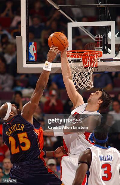 Erick Dampier of the Golden State Warriors has his shot attempt blocked by Mehmet Okur of the Detroit Pistons during NBA action January 3, 2004 at...