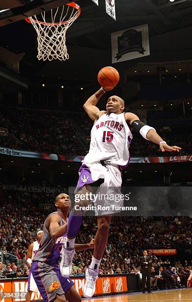 Vince Carter of the Toronto Raptors throws down the slam in front of Leandro Barbosa of the Phoenix Suns January 4, 2004 at the Air Canada Centre in...