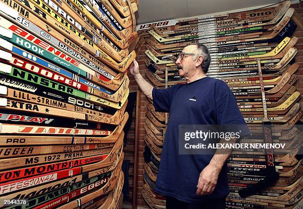 Russian Valery Zlobin inspects hockey sticks in his collection, fixed on the walls of in his flat in Moscow, 05 January 2004. Zlobin started to...