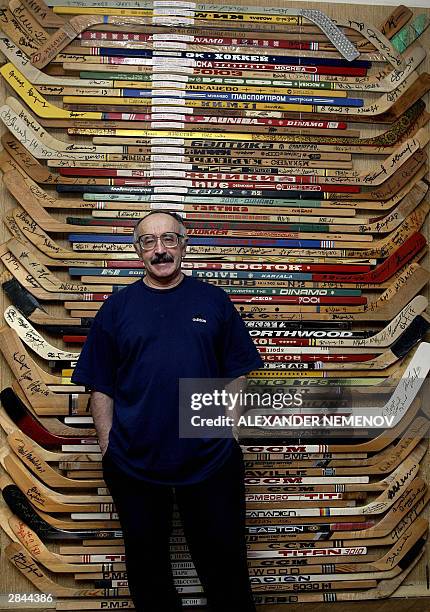 Russian Valery Zlobin poses in front of hockey sticks, a part of his collection, fixed on the walls of in his flat in Moscow, 05 January 2004. Zlobin...