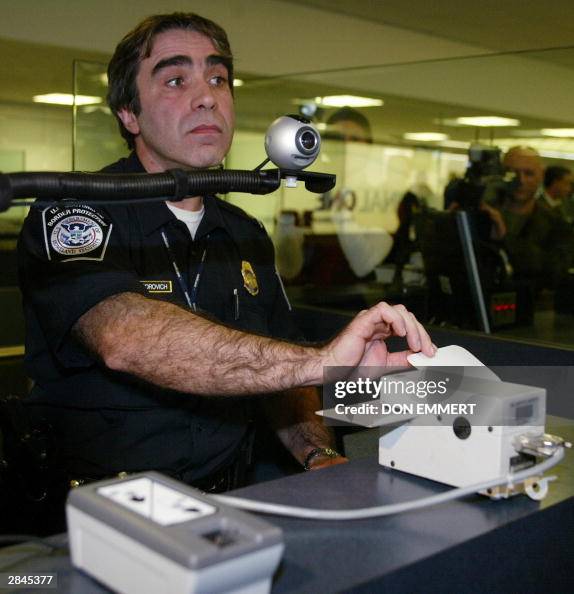 Customs Officer shows a fingerprinting and ID scanning machine at JFK ...