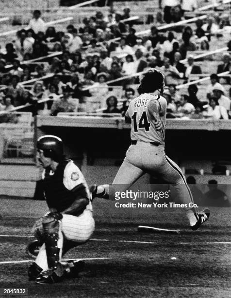 Philadelphia Phillies third baseman Pete Rose runs across home plate to score a run as New York Mets catcher Alex Trevino awaits a throw from Lee...