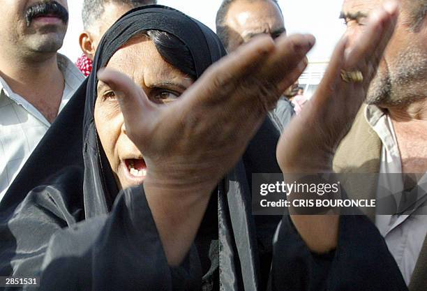 An Iraqi woman complains to journalists gathered outside Abu Gharib prison, 35 kms west of Baghdad, 08 January 2004. The woman expressed doubts about...