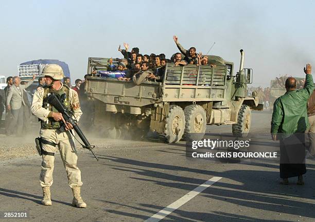 Released Iraqi prisoners ride out of Abu Gharib prison, 35km west of Baghdad, 08 January 2004 under the guard of a US military policeman. Around 60...