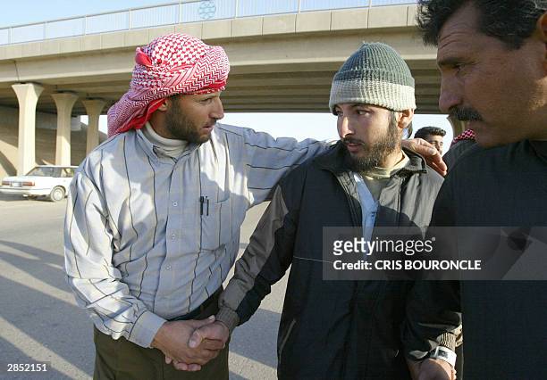 Released prisoner walks with relatives along the highway outside Abu Gharib prison, 35km west of Baghdad, 08 January 2004. Around 60 Iraqi prisoners...