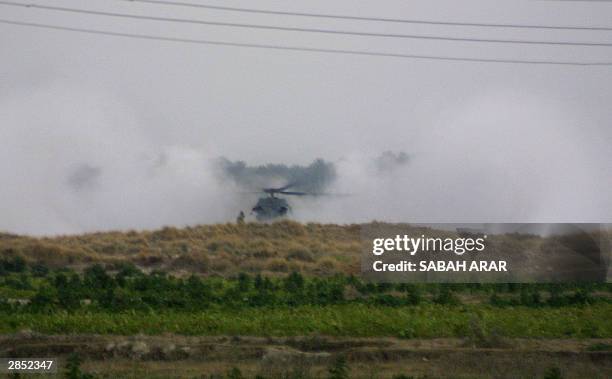 Smoke billows from a US military UH-60 Blackhawk helicopter outside Nuamiya, 5km southeast of the restive town of Fallujah, 08 January 2004 after it...