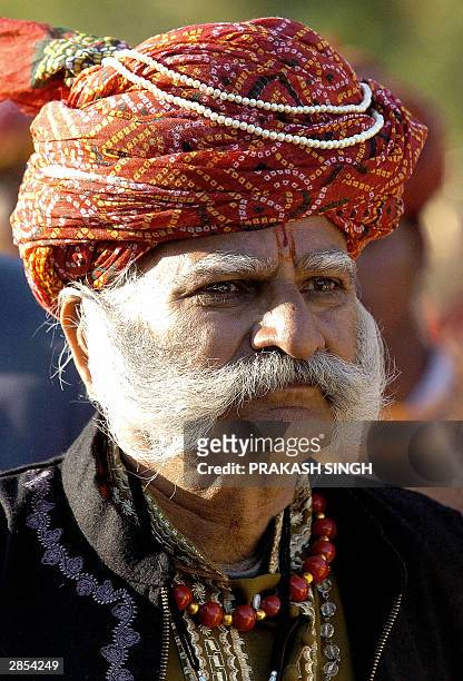 Rajasthani folk dancer wearing a traditional turban waits to perform during the inauguration of the 'Jaipur Heritage International Festival 2004' at...