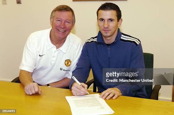 Sir Alex Ferguson of Manchester United poses with new signing Liam Miller at Carrington Training Ground on January 8, 2004 in Manchester, England.