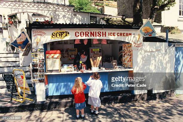 england,cornwall,polperro,two girls at ice-cream kiosk - cornwall england imagens e fotografias de stock