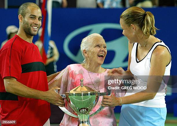 James Blake and compatriot Lindsay Davenport of the US, joke with Lucy Hopman , wife of the late Harry Hopman, at the trophy presentation after they...