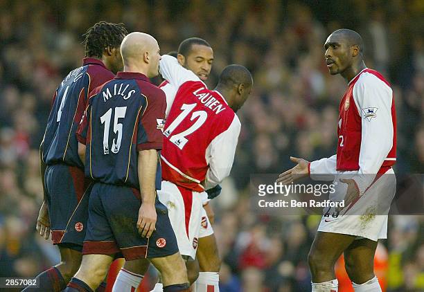 Sol Campbell of Arsenal argues with Danny Mills of Middlesbrough while Thierry Henry celebrates with Lauren after scoring the fisrt goal for Arsenal...
