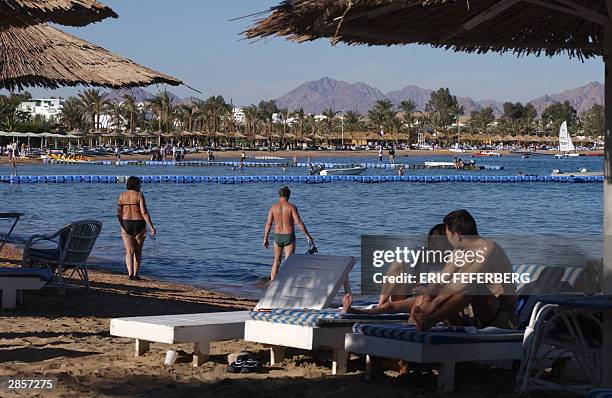 Tourists on holidays take in the sun on a beach in Naama Bay, 10 January 2004 in Sharm el Sheikh. AFP PHOTO ERIC FEFERBERG