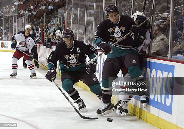 Ruslan Salei of the Anaheim Mighty Ducks and teammate Sergei Fedorov win the puck off the boards against the Columbus Blue Jakets in the second...