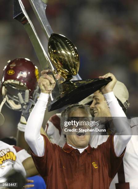 Head coach Pete Carroll of the USC Trojans celebrates with the Tournament of Roses trophy after defeating the Michigan Wolverines in the 2004 Rose...