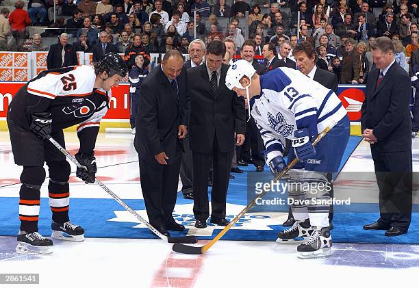 Hockey Hall of Fame inductees Grant Fuhr, Pat LaFontaine, and Brian Kilrea drop the puck for the opening face off between center Keith Primeau of the...