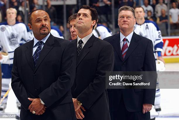 Hockey Hall of Fame inductees Grant Fuhr, Pat LaFontaine, and Brian Kilrea are stand on the ice before the game between the Toronto Maple Leafs and...