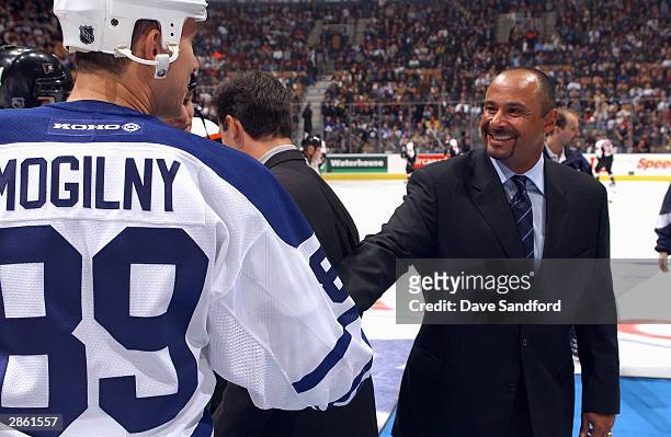 Grant Fuhr 2003 Hockey Hall of Fame inductee shakes hands with right wing Alexander Mogilny of the Toronto Maple Leafs during the game against the...