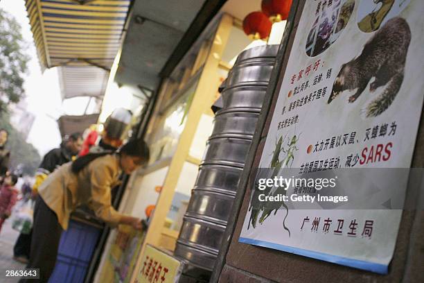 Propaganda poster that promotes the killing of rats, cockroaches and civet cats as a "patriotic" act, is attached to a wall in Guangzhou's business...