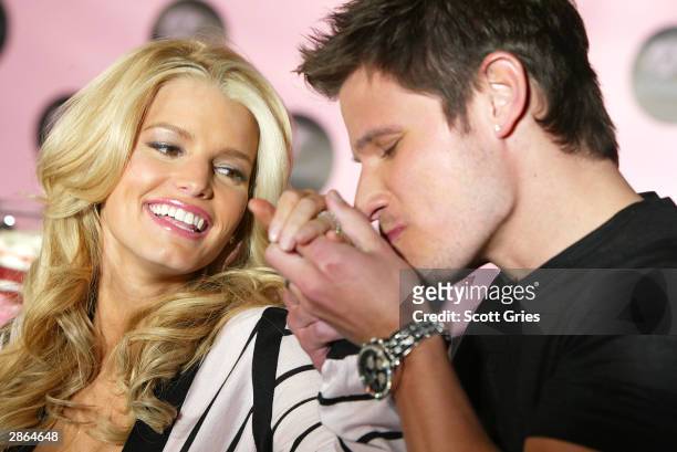 Singer Nick Lachey kisses the hand of wife Jessica Simpson at a press conference to launch Dessert, an edible fragrance and body care line, at...