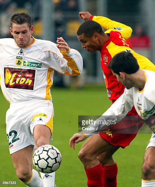 Le Mans' forward Daniel Cousin fights for the ball with Nantes' defender Sylvain Armand and Loic Guillon during their Ligue cup quarter of finale...
