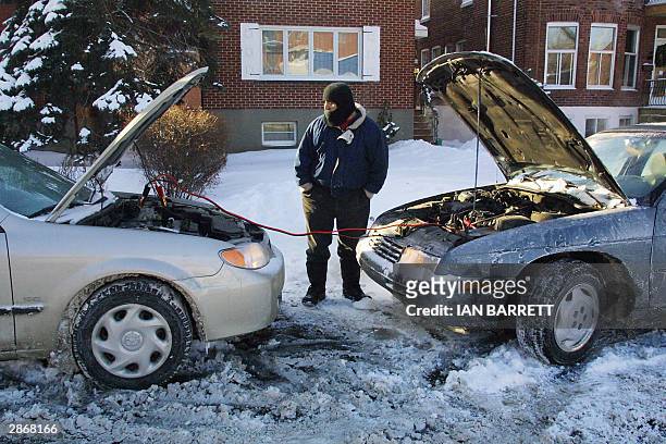 Man boosts car batteries to revive them in freezing cold in Montreal on 14 January, 2003. The area has been hit repeatedly by spells of bitter cold....