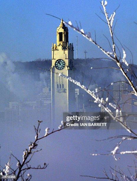 The clock tower at Montreal's old port looms out of the mist-covered St. Lawrence River 15 January, 2004 as the city continues its deep freeze...