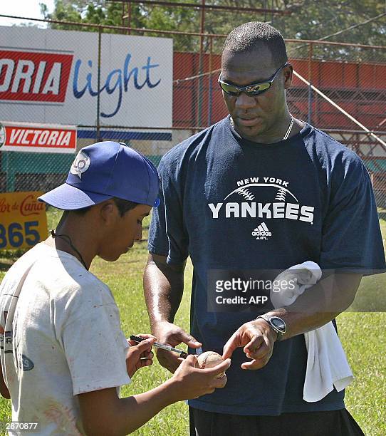 Jose Ariel Contreras, pitcher cubano de los Yankees de New York, entrega una pelota autografiada a un fanatico, el 15 de enero de 2004, durante el...