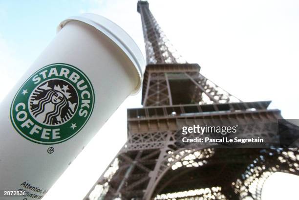 Starbucks cup is seen in front of the Eiffel tower as the new Starbucks store opened for the public, the first ever in France, January 16, 2004 in...