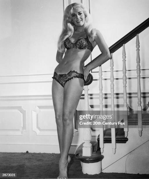 Promotional portrait of American actor Edy WiIlliams leaning aganist a staircase, wearing a bra and panties, in 'The Secret Life of an American...
