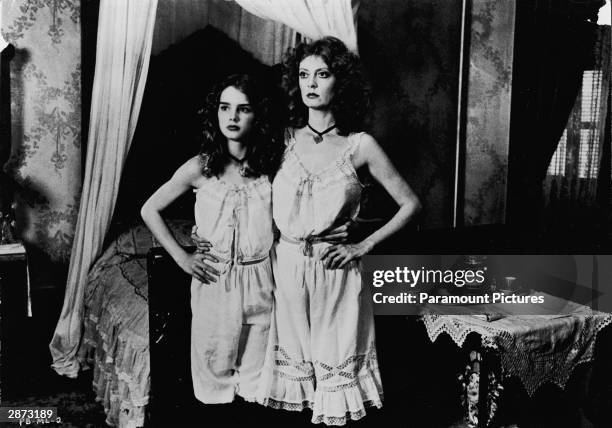 American actors Susan Sarandon and Brooke Shields stand together, wearing matching slips in a still from the film, 'Pretty Baby,' directed by Louis...
