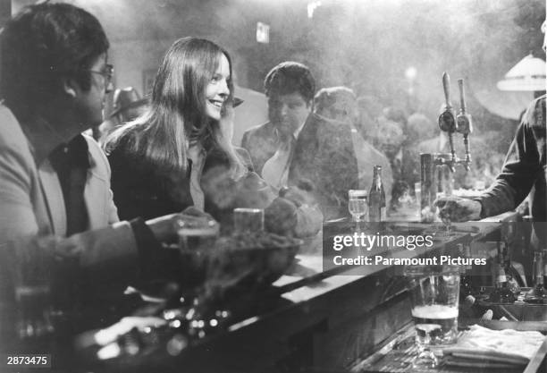 American actor Diane Keaton sits at a bar crowded with men in a still from the film, 'Looking For Mr. Goodbar,' directed by Richard Brooks, 1977.