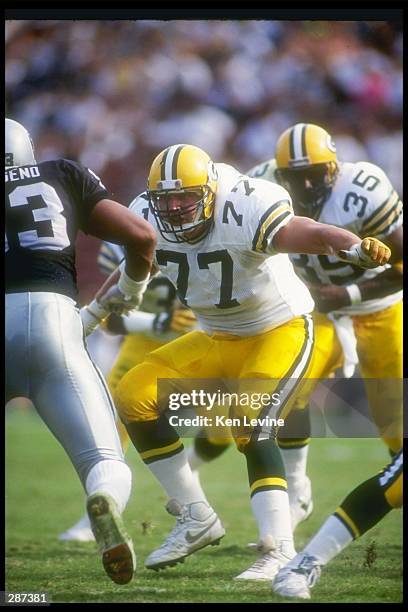 Offensive lineman Tony Mandarich of the Green Bay Packers looks to block a Los Angeles Raiders player during a game at the Los Angeles Memorial...