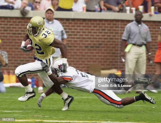 Fullback Johnathan Jackson of the Georgia Tech Yellow Jackets attempts to break out of the tackle from safety Karibi Dede of the Auburn Tigers during...