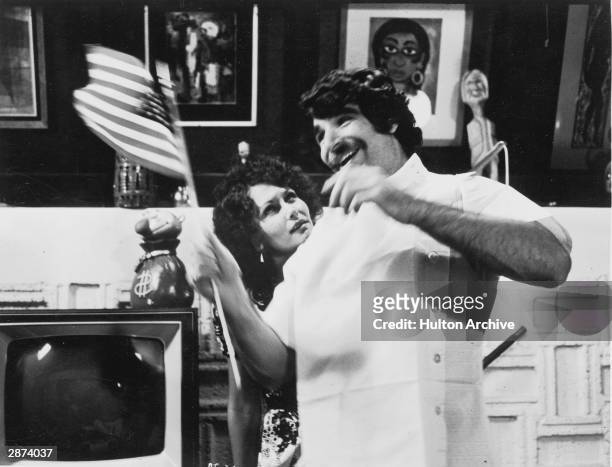 Actor Harry Reems waves an American flag as actor Linda Lovelace looks on in a still from the film, 'Deep Throat,' directed by Gerard Damiano, 1972.