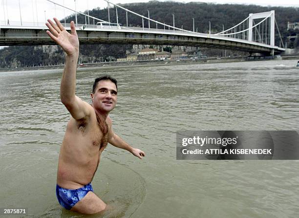 Hungarian vegetarian sportsman Gyorgy Schirilla Jr. Waves at his fans on the bank of the Danube River in Budapest 17 January 2004 as he steps into 1...